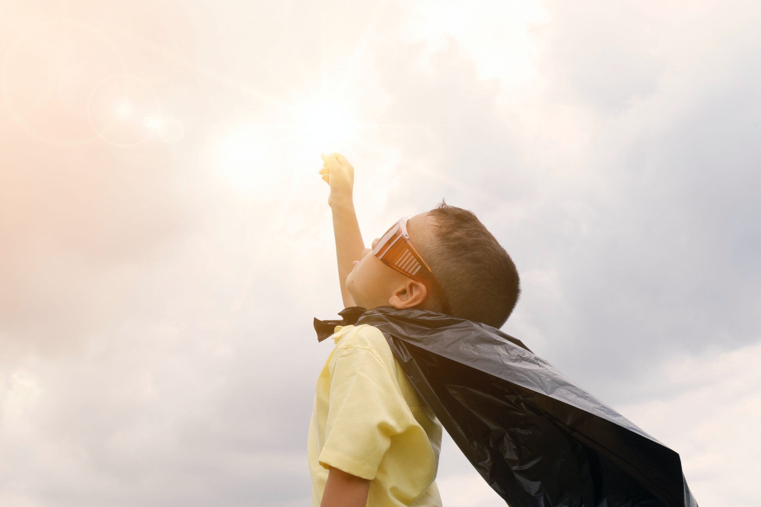 Boy wearing a superman cape looking confident after family therapy in Wesley chapel, fl. Online therapy in Florida can help with family counseling, play therapy  and couples therapy near Tampa, FL.